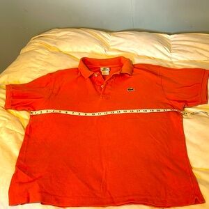 Lacoste polo in coral/pastel orange. Size 6 measures 23 in across/24 in length